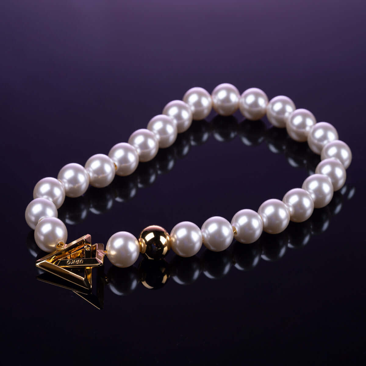 UPKO "Moist Eyes" Pearl Necklace Collar featuring shimmering pearls and a gold accent charm on a reflective surface.