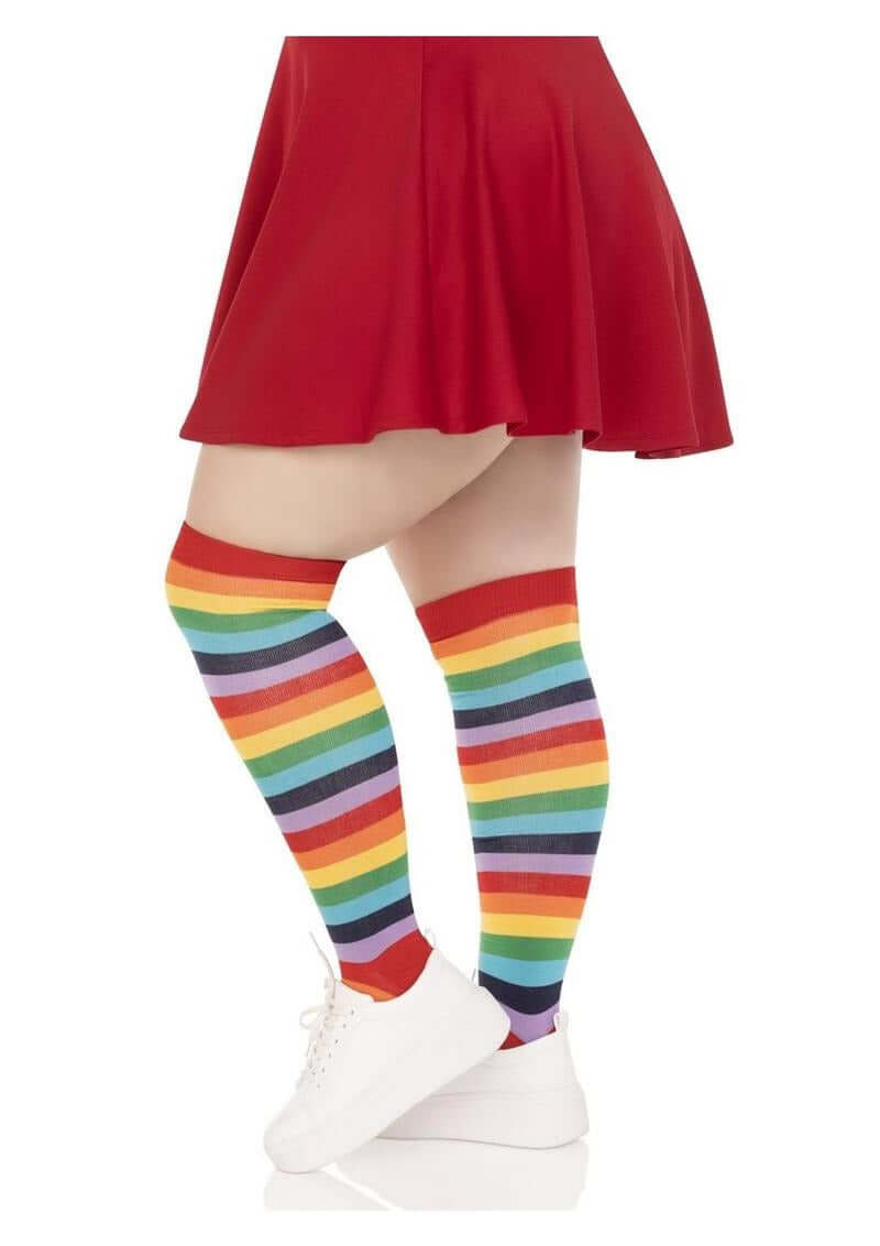 Leg Avenue Lycra Acrylic Rainbow Thigh High 1X 2X worn with a red skirt and white sneakers, featuring colorful striped design.