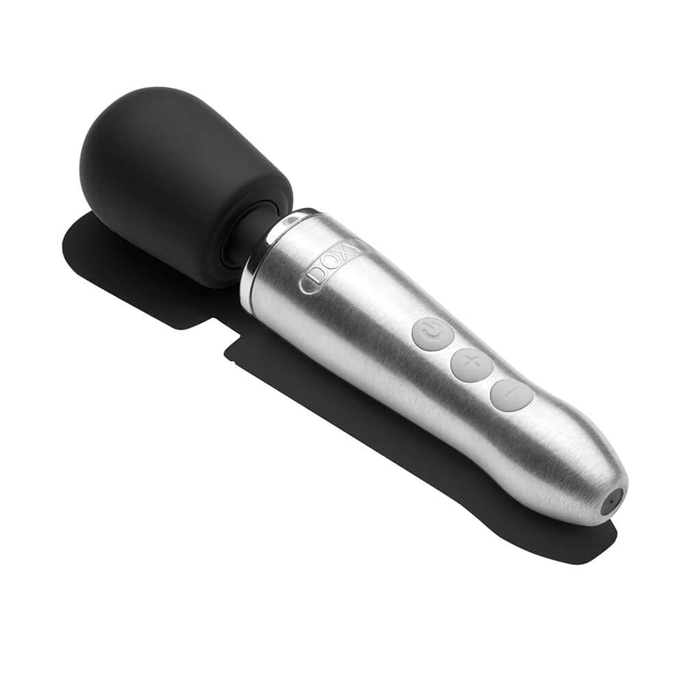 Doxy Go Travel-sized Wand Massager Silver laid on a surface, showcasing its sleek design and powerful features.