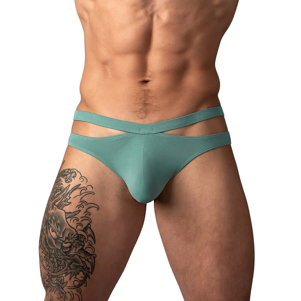 Male Power Eco Cozy Cutout Thong Green L XL worn by a model, showcasing its modern style and comfort.