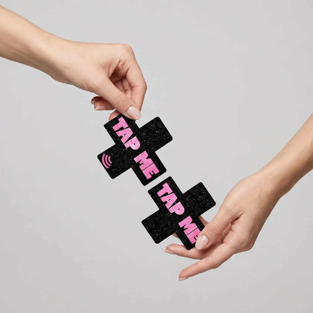 Neva Nude Tap Me Pink X Smart Nfc Pasties held between two hands, showcasing fashionable design and NFC technology.
