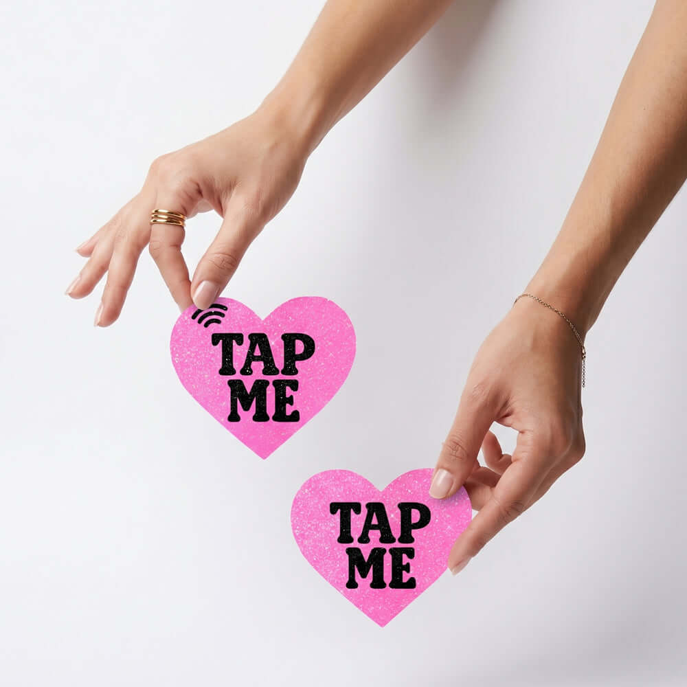 Neva Nude Tap Me Pink Heart Smart Nfc Pasties held in hands, showcasing innovative NFC technology.