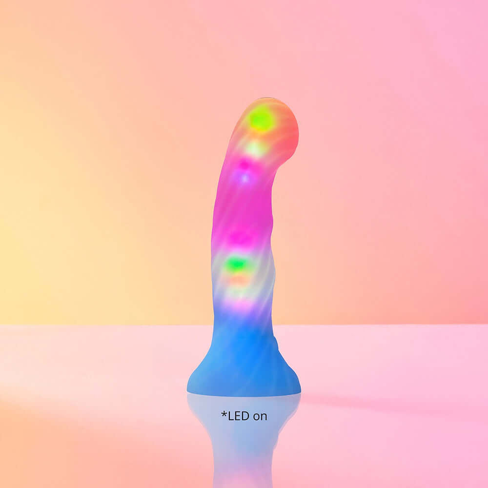 Love To Love Dildo LED Candy Loop illuminated with colorful LED lights against a pastel background.