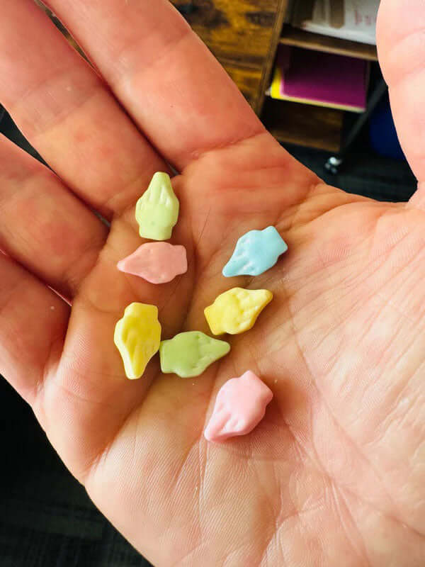 Colorful middle-finger shaped candies from the Fuck You You Fucking Fuck Candy 3 Oz Bag held in a hand.