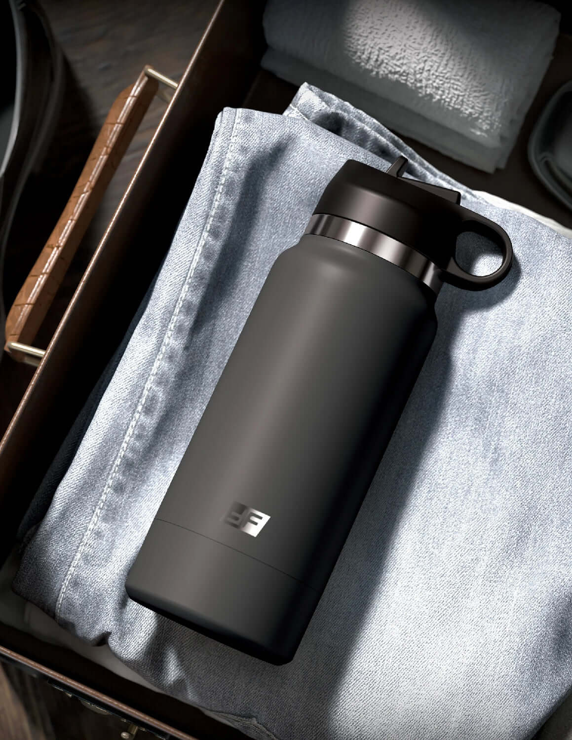 Discreet grey Fuck Flask on denim with brown accents, designed to mimic a reusable water bottle for on-demand hydration.