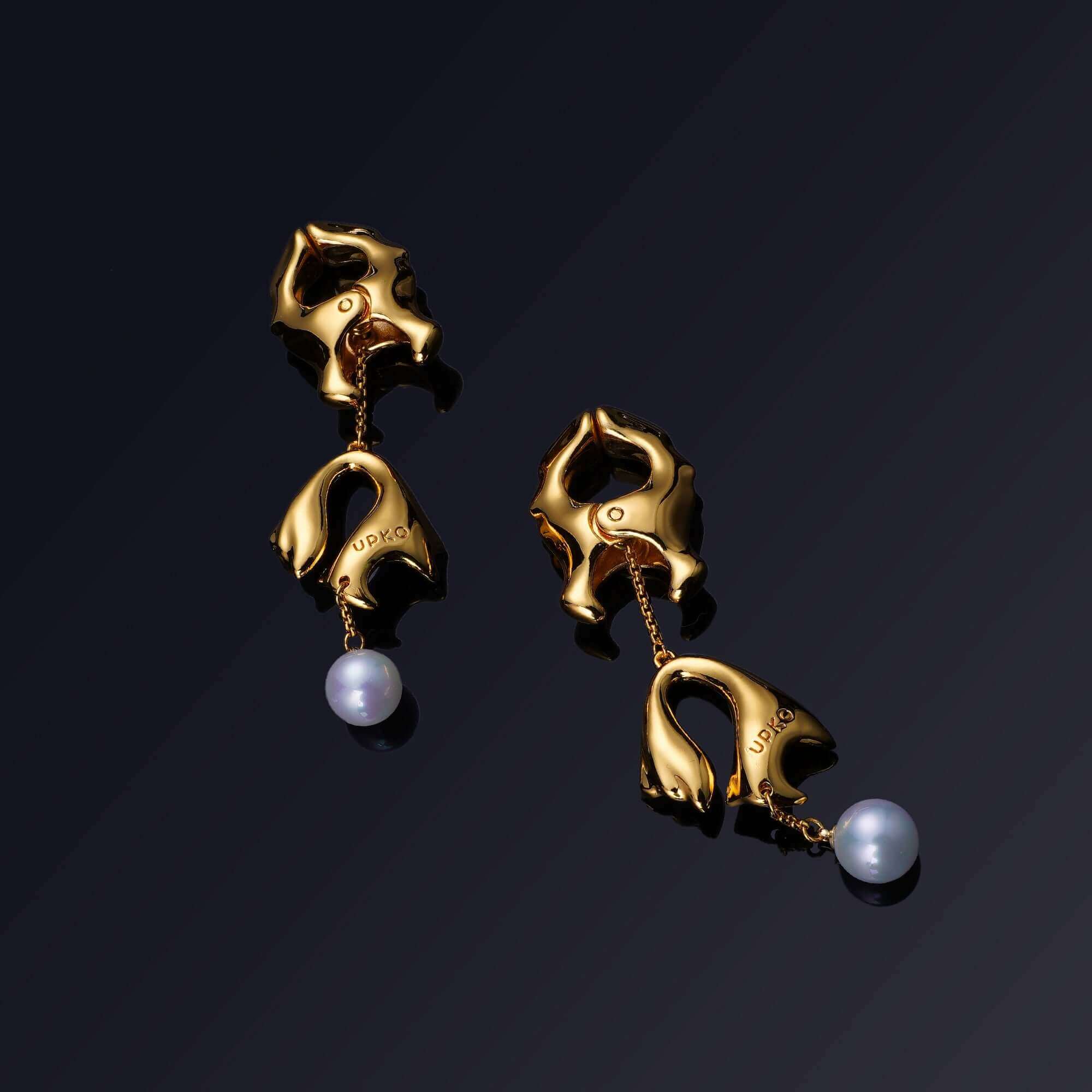 Elegant gold earrings with pearl accents, showcasing a modern design inspired by natural shapes.