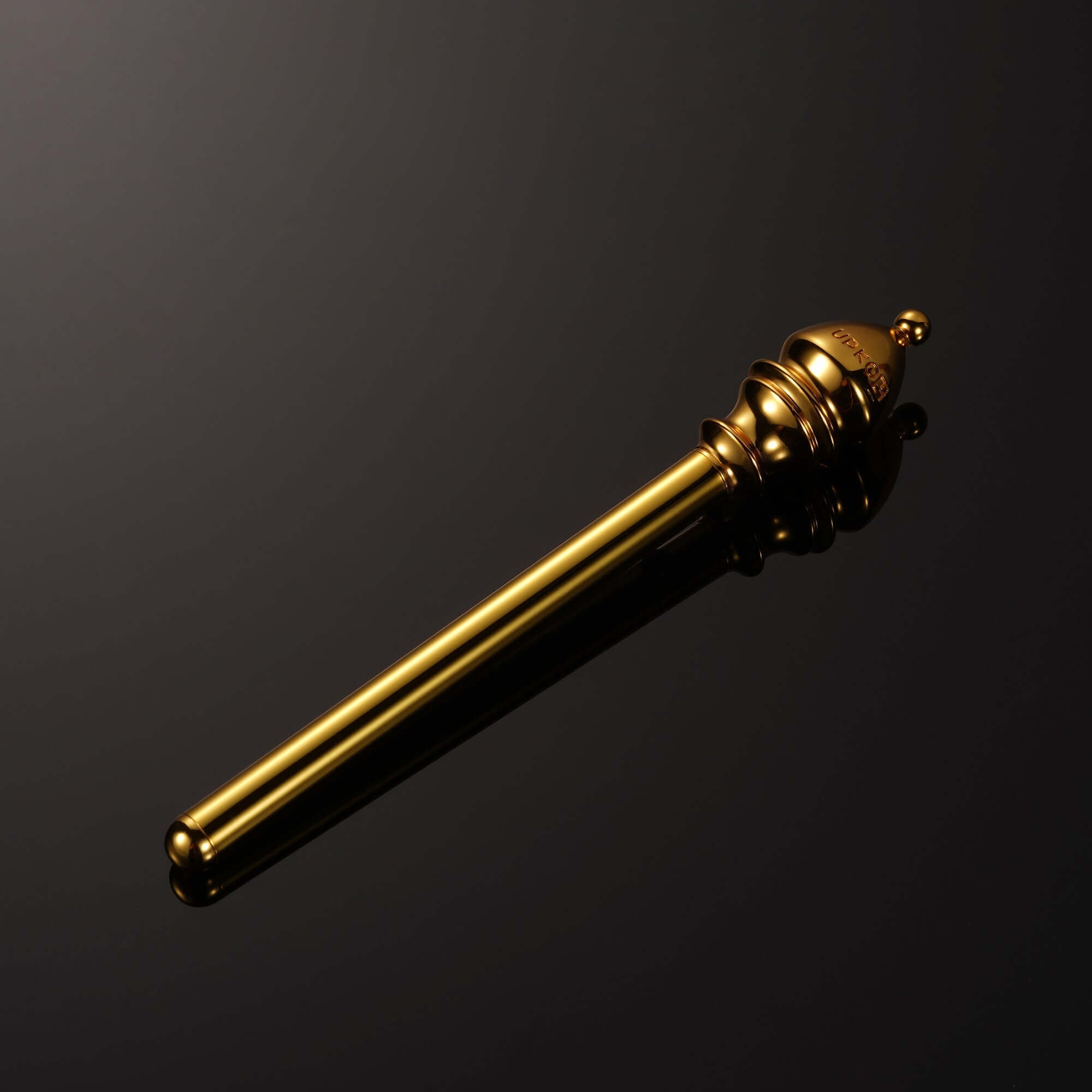 Mini vibrator from "The Chess" Collection - Bishop, sleek gold design on a reflective surface.