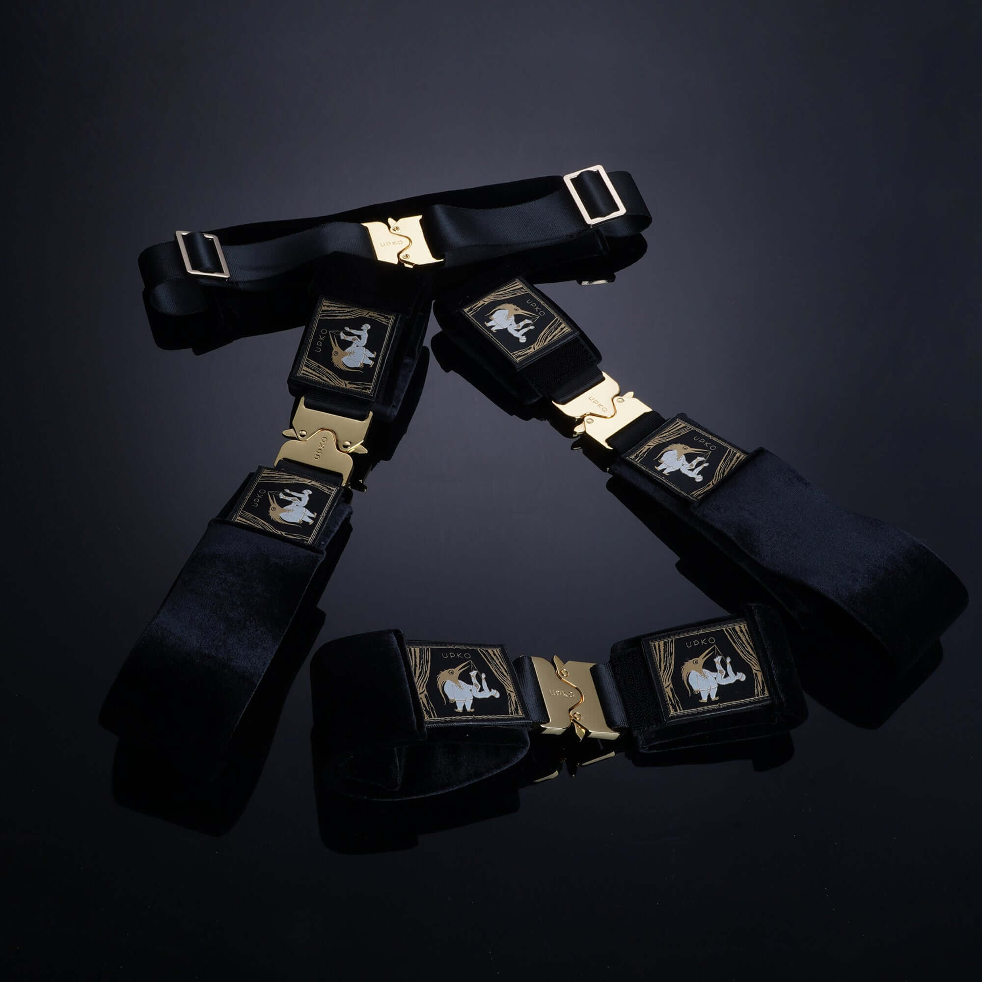 Clack Bondage Restraints Gear featuring black straps with gold buckles, designed for secure and versatile use.
