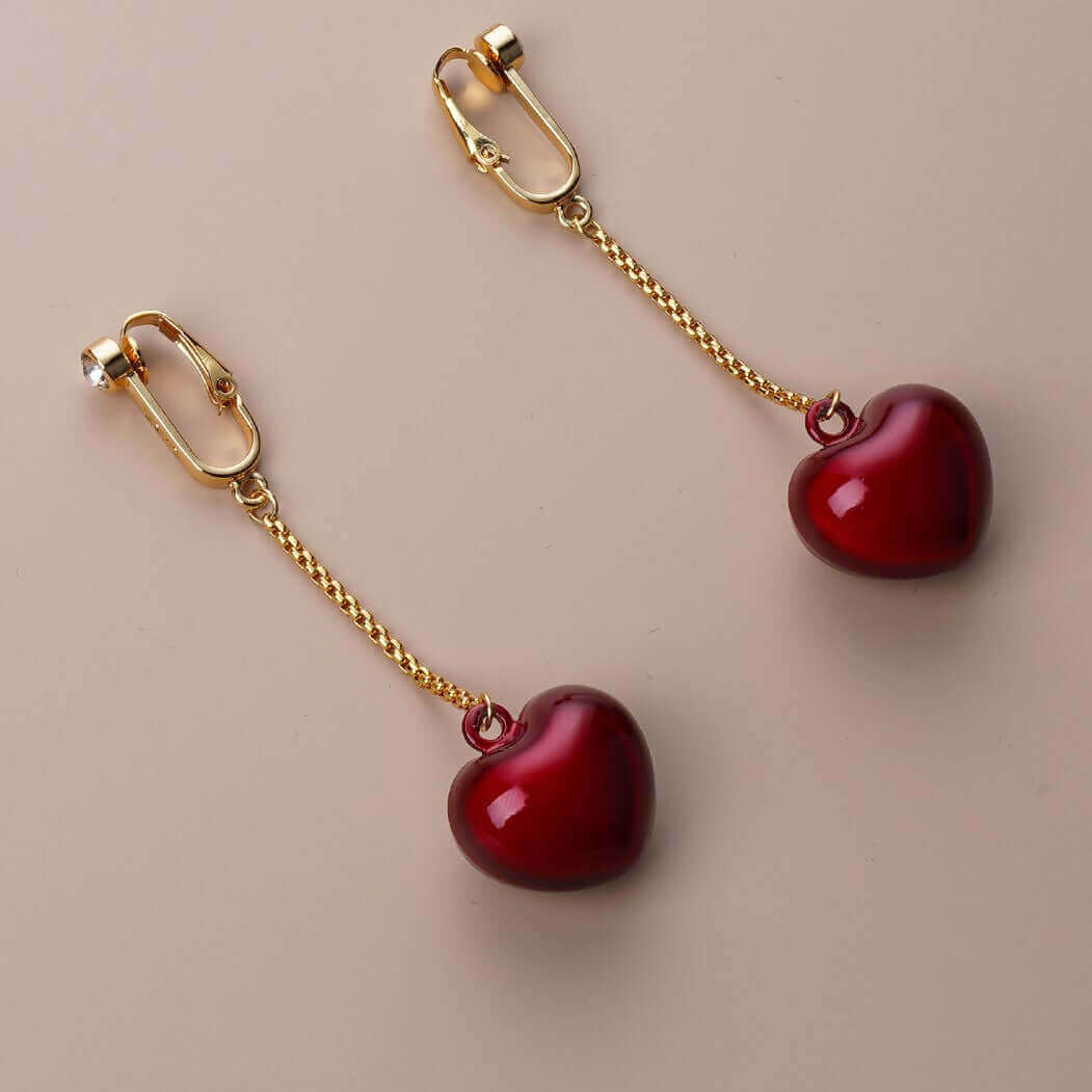 Elegant heart-shaped non-pierced clitoral jewelry with gold chain by UPKO, featuring red rhinestone embellishments.