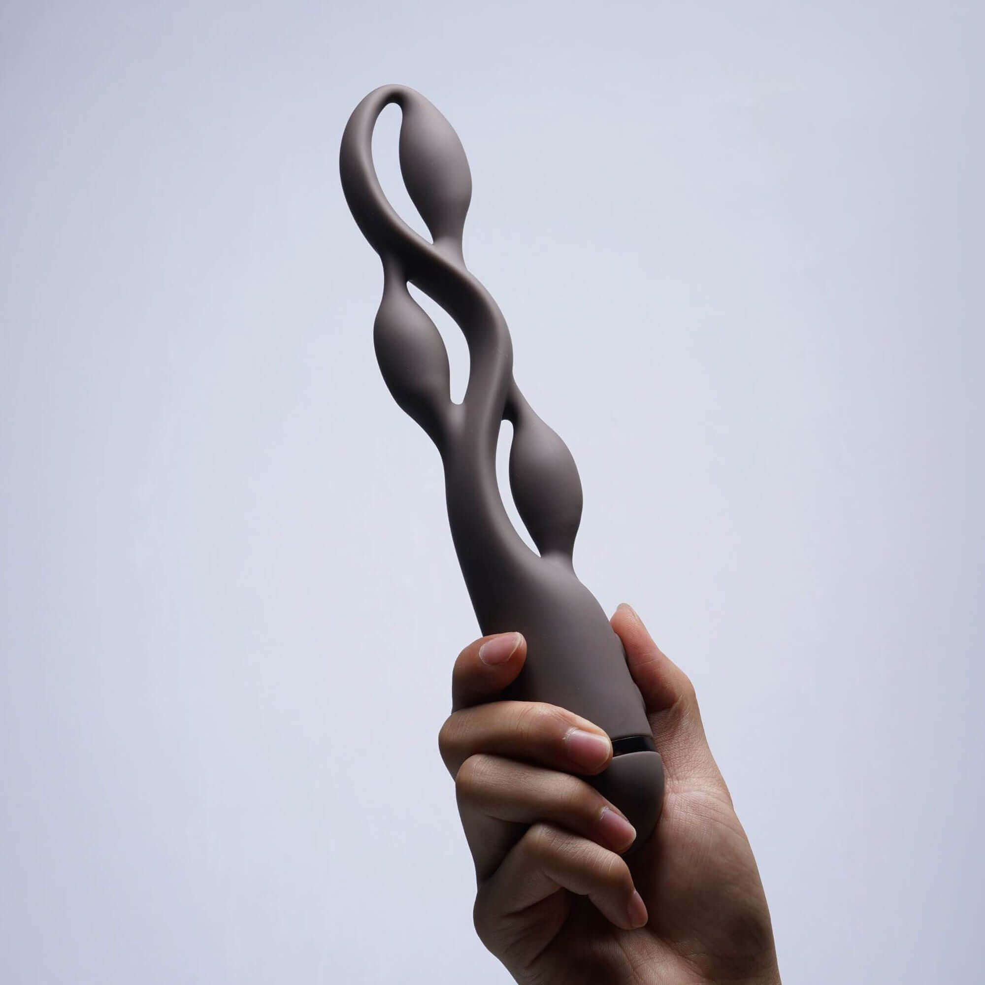 Hand holding UEROS Multi-motor Pulse Vibrator Brown with unique design and pulse vibration for enhanced pleasure.