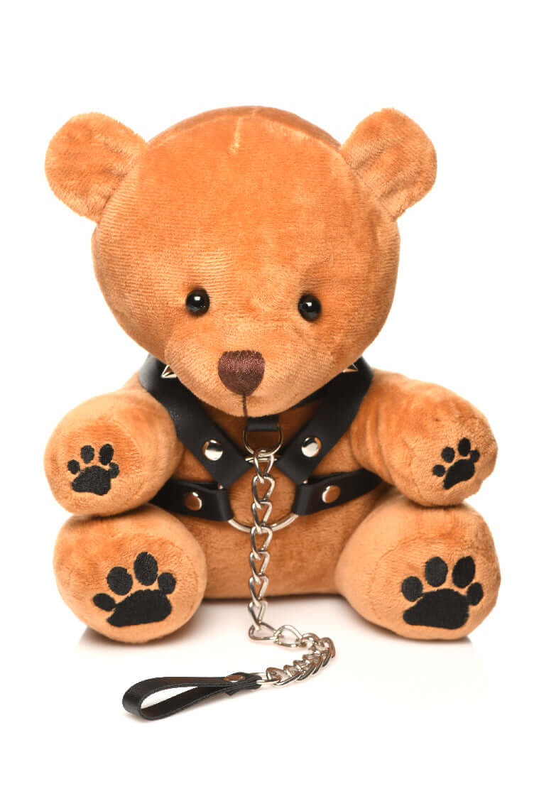 Light peach fur bondage teddy bear wearing a faux leather harness and leash with metal O-rings, paws embroidered on feet.
