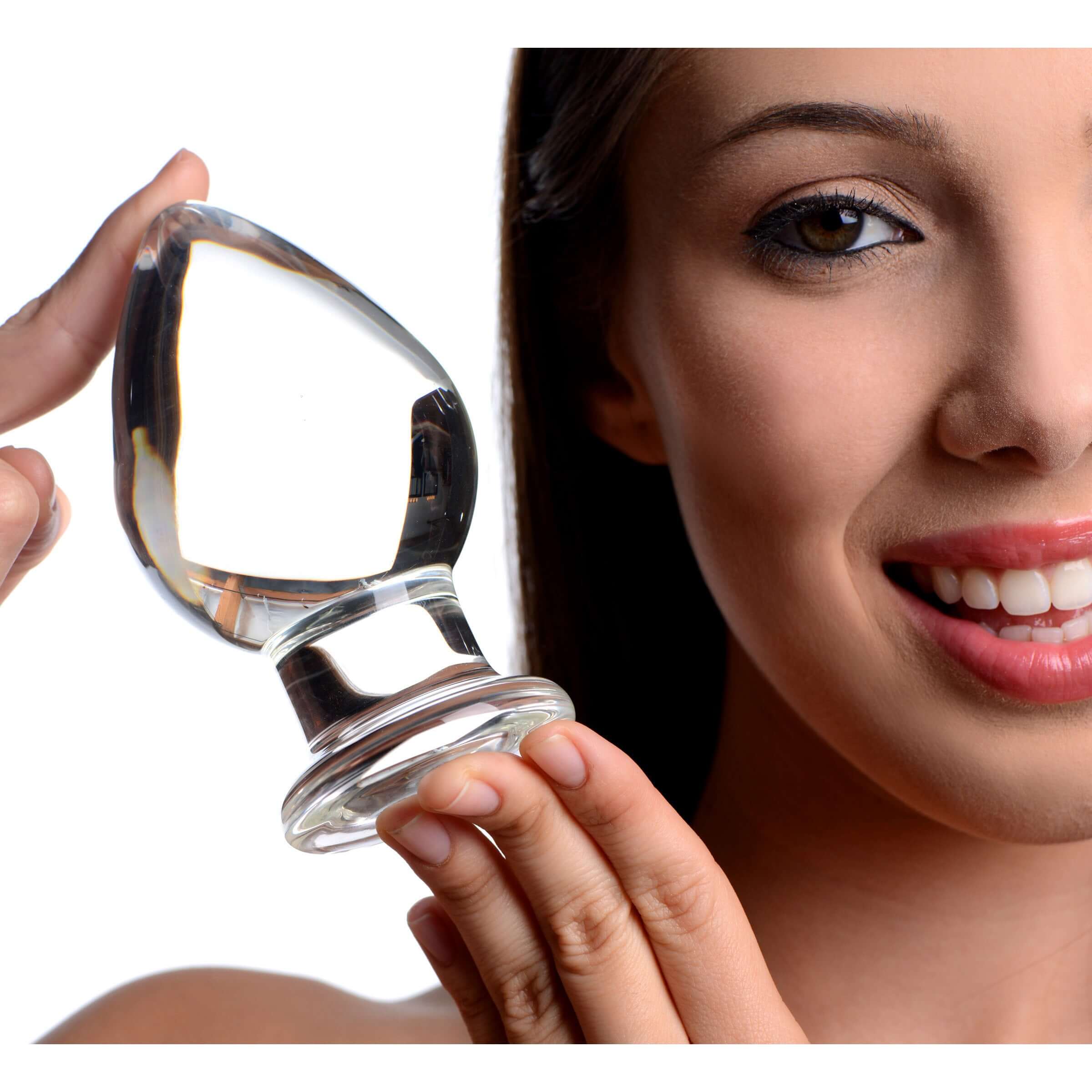 Woman holding a Prisms Molten Wide Glass Butt Plug, showcasing its elegant design and clear glass finish.