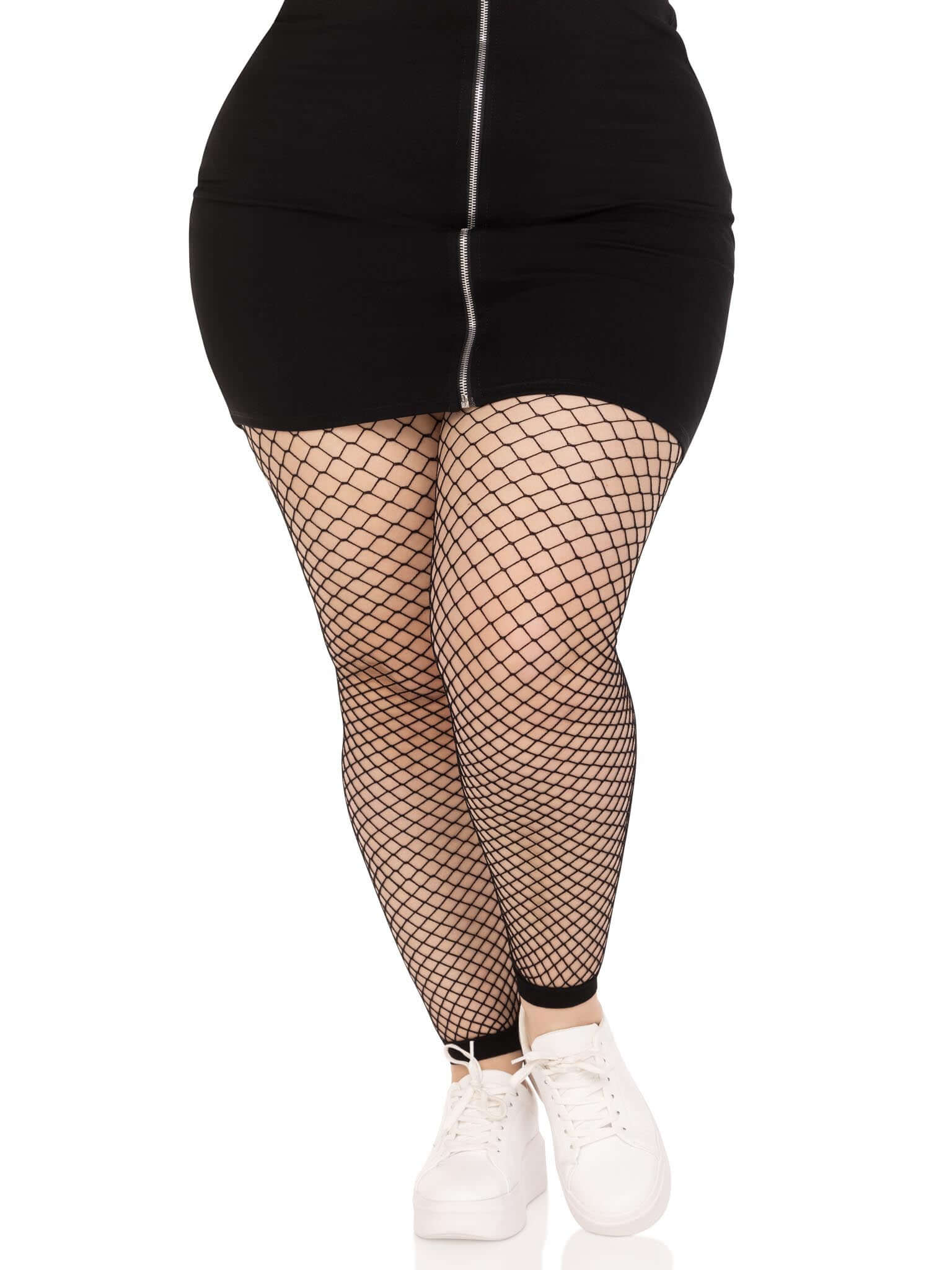 Plus size model wearing black industrial net footless tights with black skirt and white sneakers