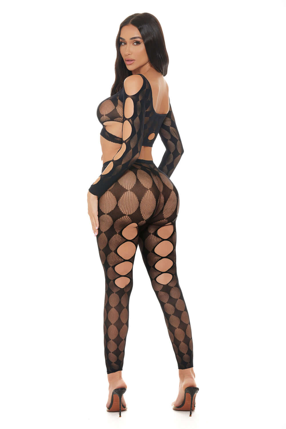 Model showcasing a sheer black Tongue Twisted crop top and leggings set with cutouts, highlighting a stylish look.