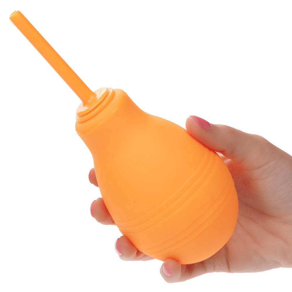 Cheeky One-Way Flow Douche Orange in hand, showing the ergonomic design and modern one-way valve.