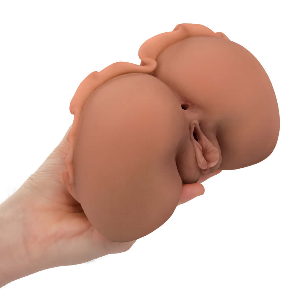 Hand holding Cheap Thrills The Homecoming Queen dual entry masturbator made from ultra life-like Pure Skin material.