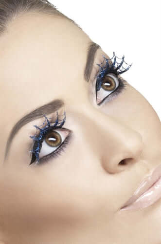 Woman wearing dramatic blue glitter spiderweb eyelashes for a sparkling eye-catching look.