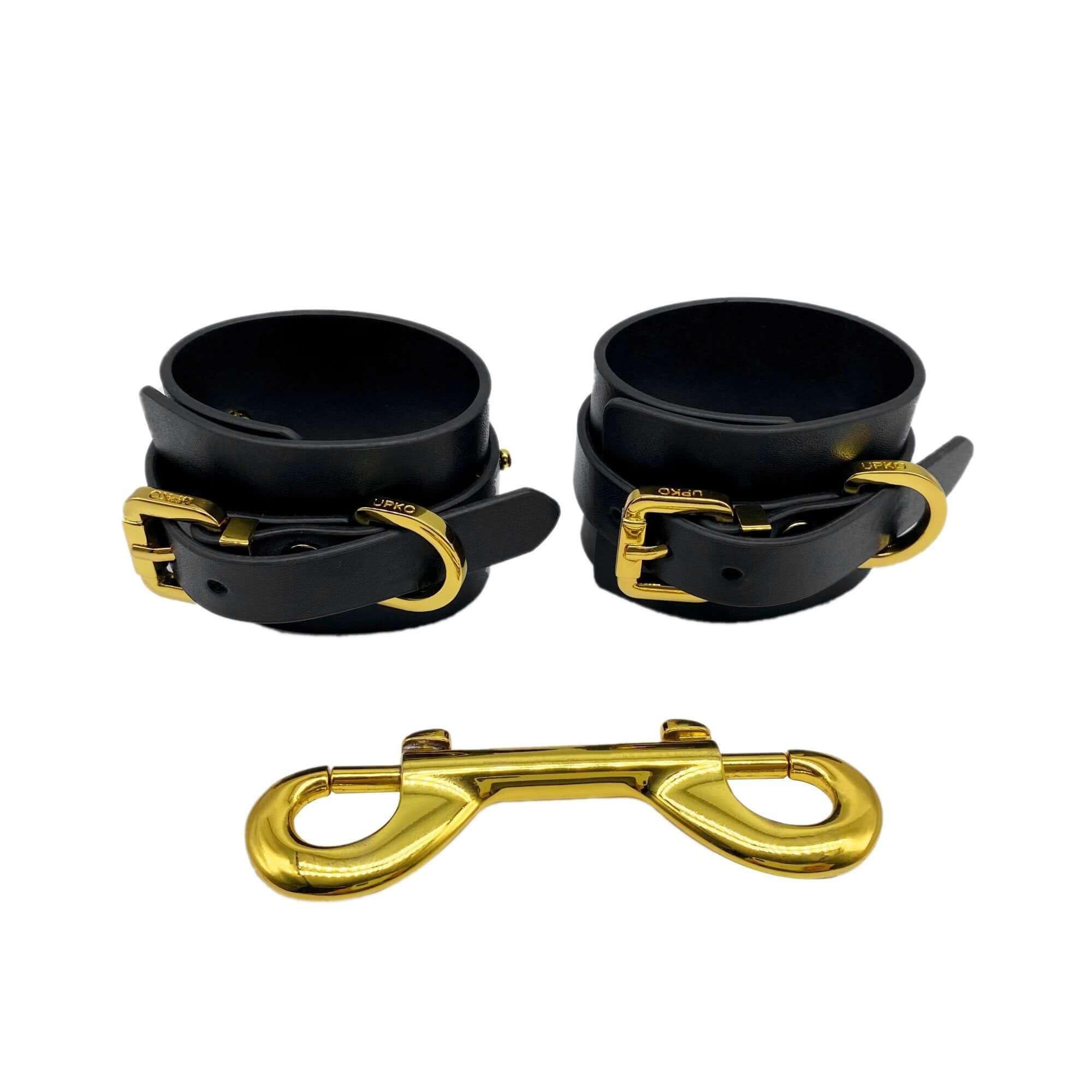 Luxury Italian leather handcuffs with gold-plated accents and double carabiner, designed for style and restraint.
