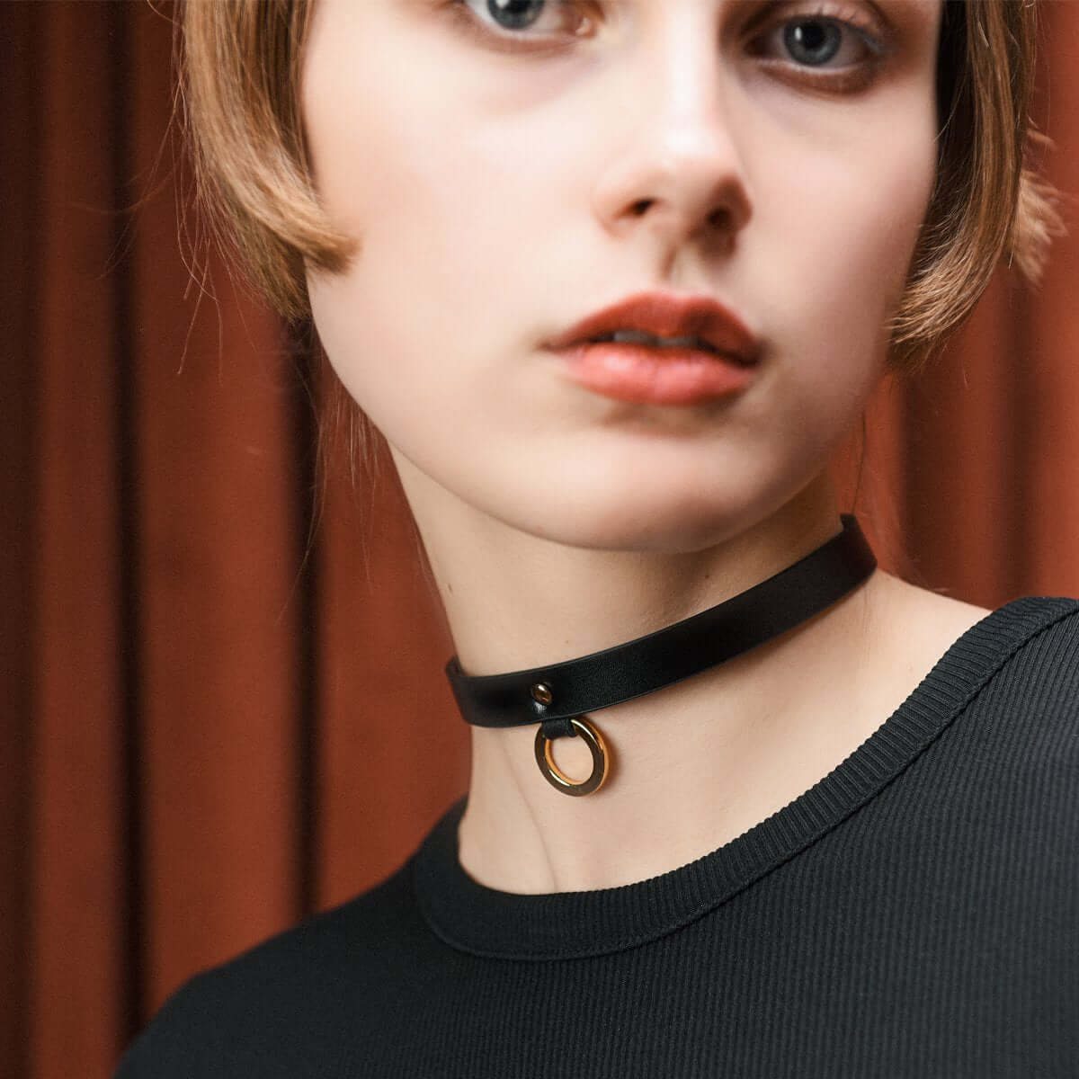 UPKO luxury Italian leather thin choker in black, featuring a gold ring, worn elegantly with a black top.