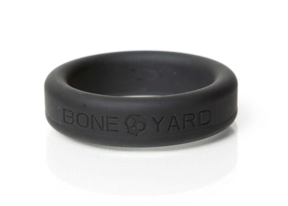 Boneyard Silicone Ring 35mm Black displayed on a reflective surface, showcasing its sleek design and durability.