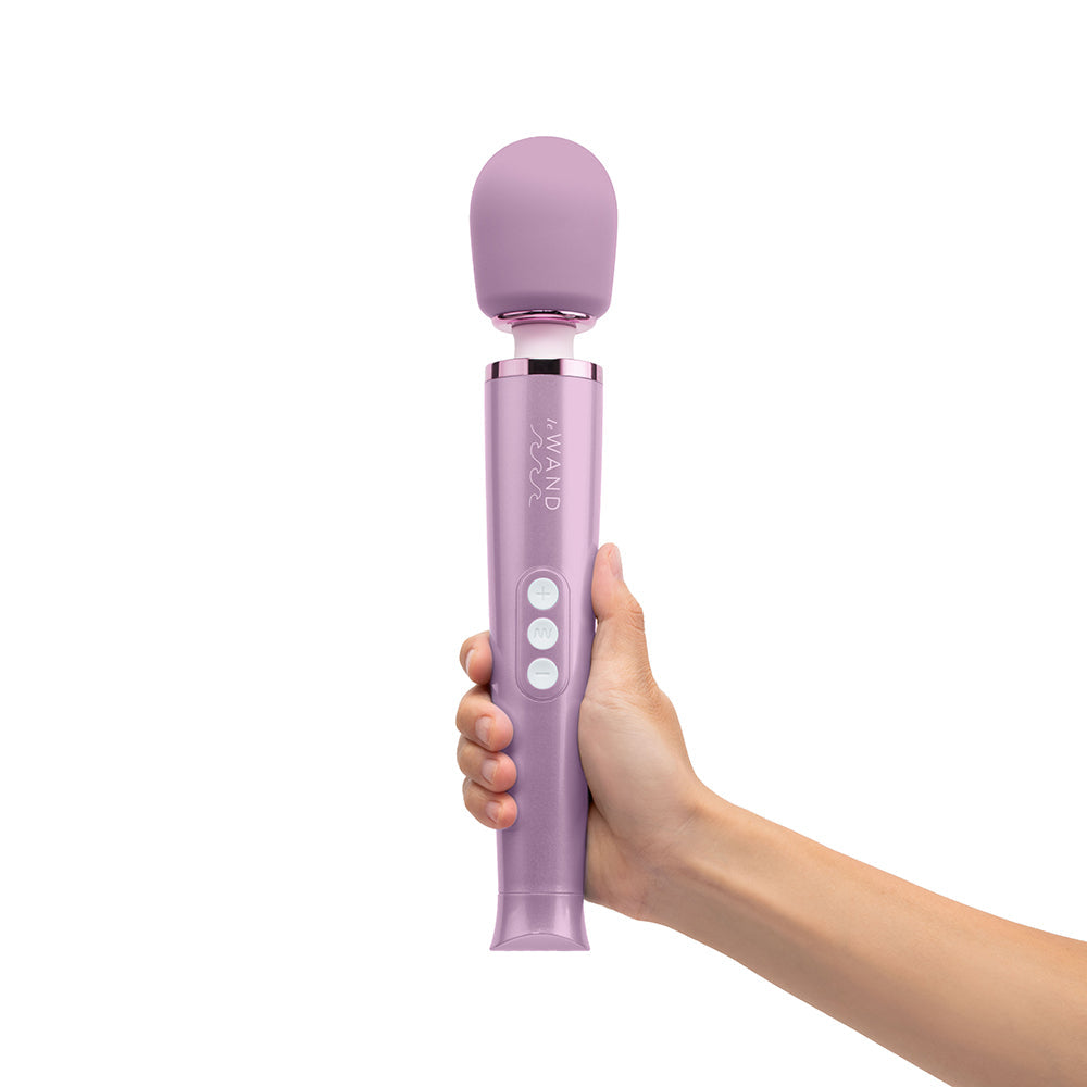 Le Wand Dive Submersible Vibrating Massager Lavender in a hand, showcasing its sleek design and control buttons.