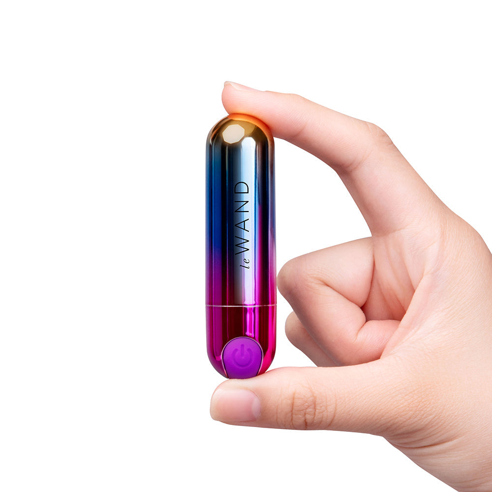 Le Wand Essentials Rechargeable Rainbow Bullet Vibrator held in hand, showcasing sleek design and vibrant colors.