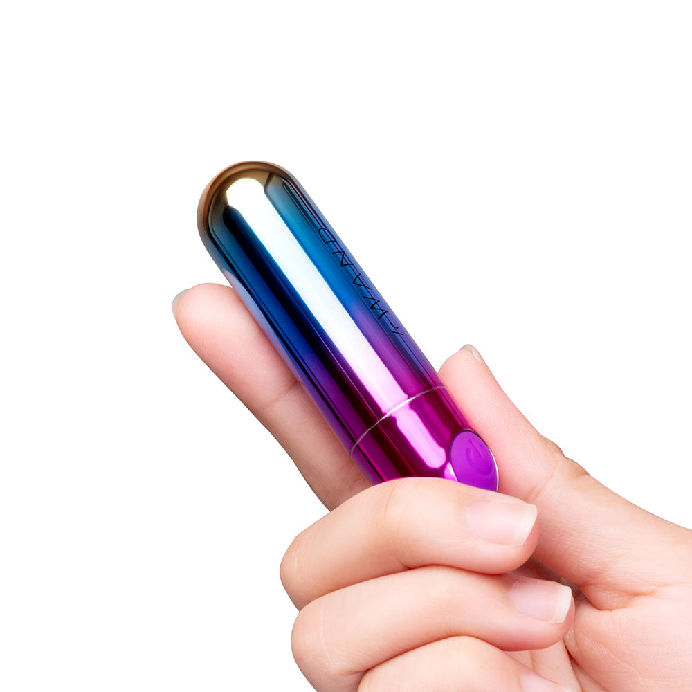 Le Wand Essentials Rechargeable Rainbow Bullet Vibrator held in hand, showcasing vibrant colors and compact design.
