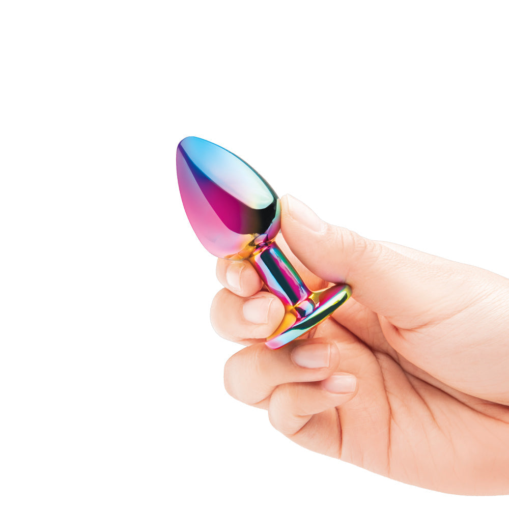 B-vibe Essentials 2-piece Rainbow Bling Anal Training Set - colorful plug held in hand, ideal for beginners.