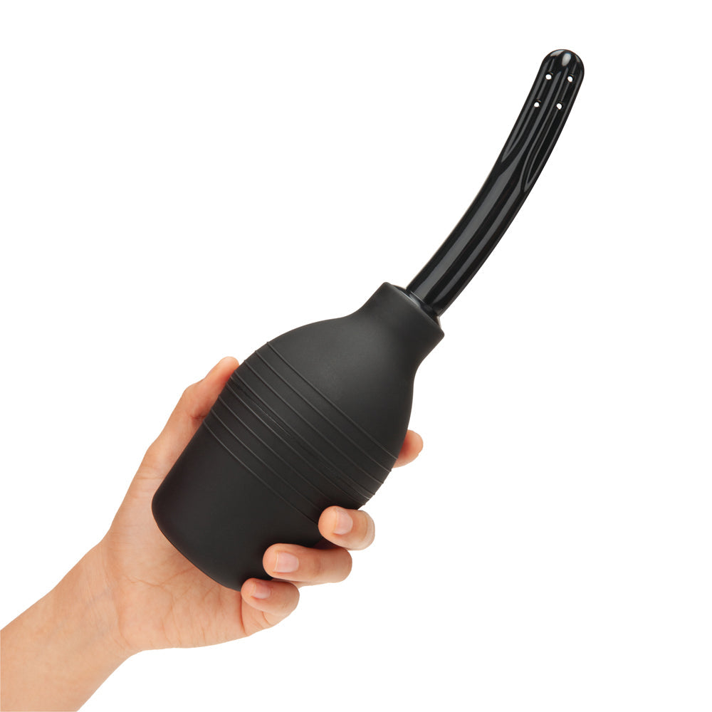 b-Vibe Essentials Enema Douche With Nozzle 310 mL Black held in hand for easy and comfortable cleansing.