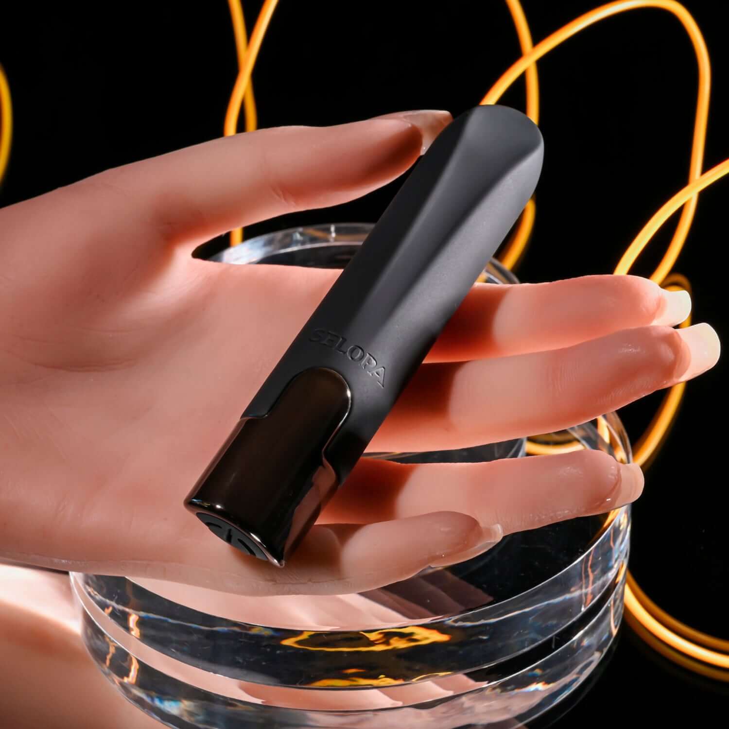 Little Buddy Bullet Vibrator in black held by a hand, showcasing its sleek design and chrome-finished base against a stylish background.