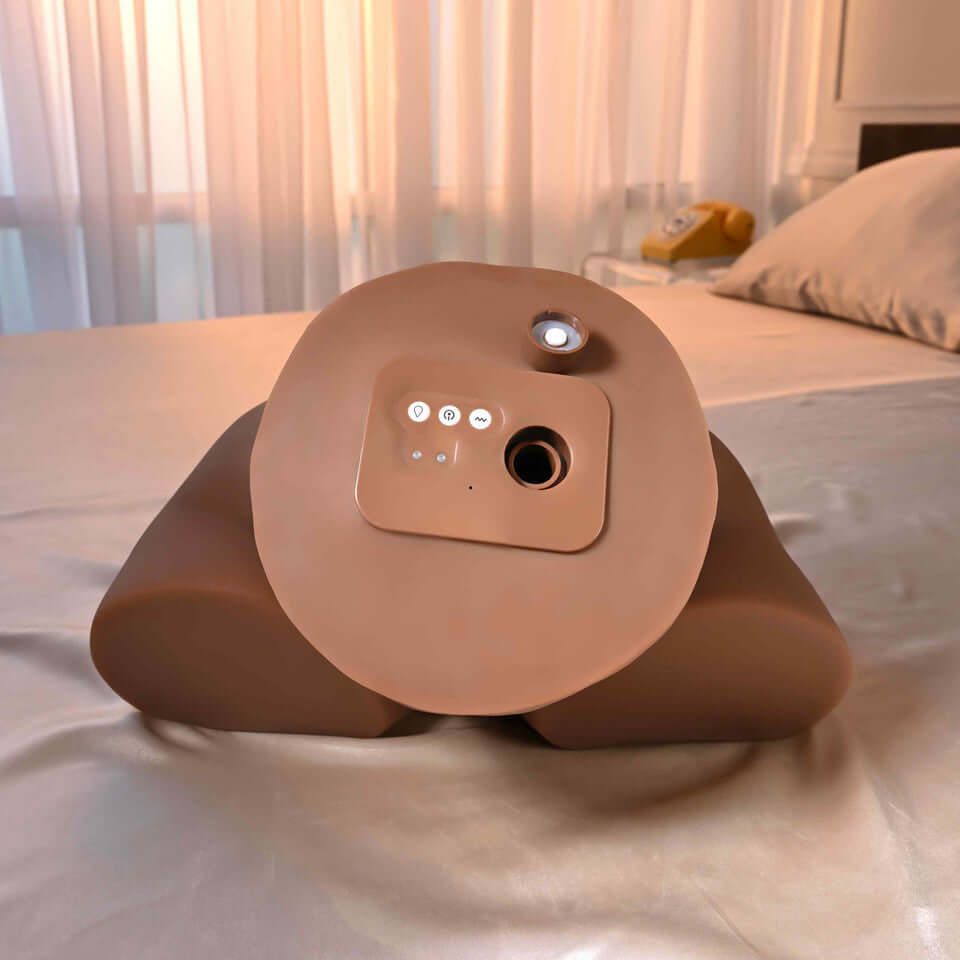 Squirt for Me XL Skyler Nicole Movie & Realistic Squirting Stroker Dark on a bed, showing its lifelike design and controls.