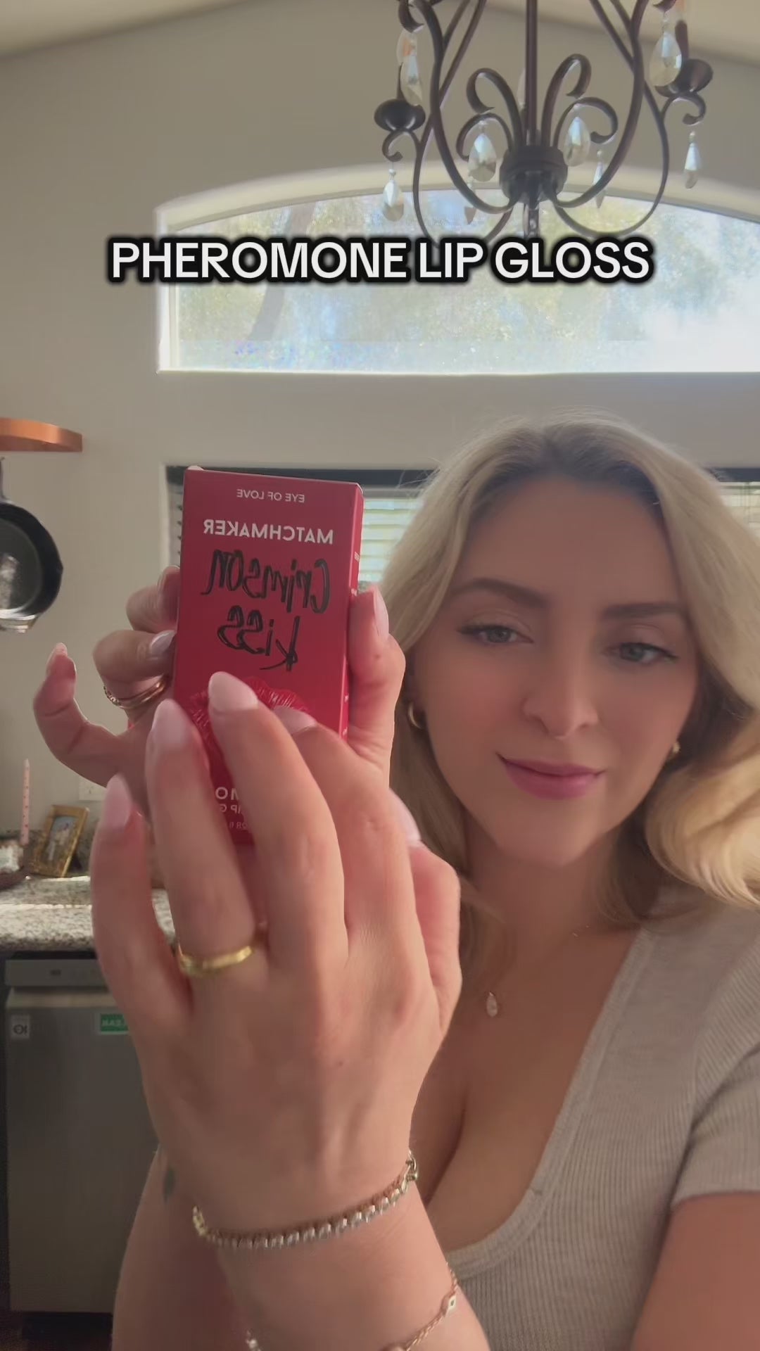 Eye Of Love Matchmaker Pheromone Ph Lip Stain Pink Pulse displayed by a model holding the product in a kitchen.