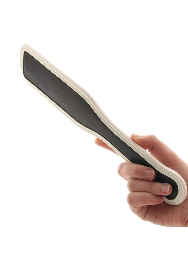 GLO Bondage Glow In The Dark Paddle Green held by a hand, showcasing its unique design and functionality.