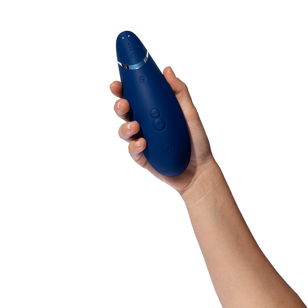 Womanizer Premium 2 Pleasure Air Clitoral Stimulator Blueberry held in hand, showcasing its sleek design and features.