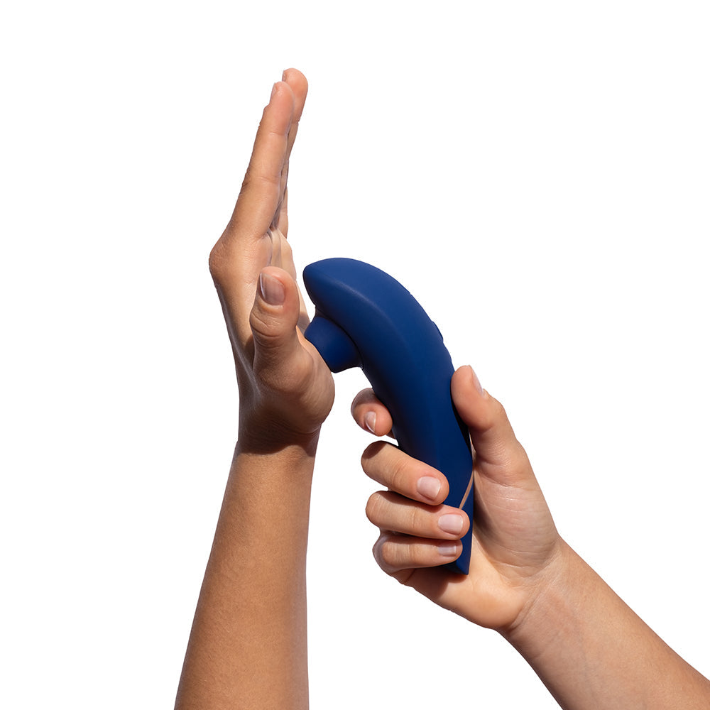 Womanizer Premium 2 Pleasure Air Clitoral Stimulator Blueberry in hand demonstrating contact-free stimulation.