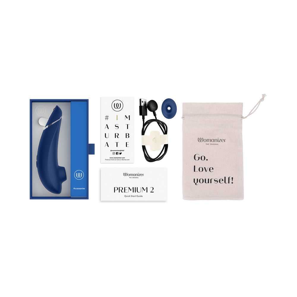 Womanizer Premium 2 Pleasure Air Clitoral Stimulator Blueberry with packaging and accessories laid out.