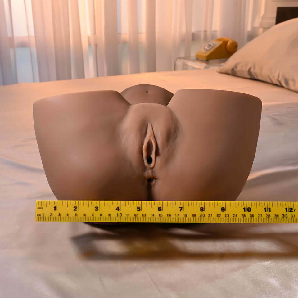 Squirt for Me XL Skyler Nicole Movie & Realistic Squirting Stroker Dark displayed on a bed with a measuring tape.