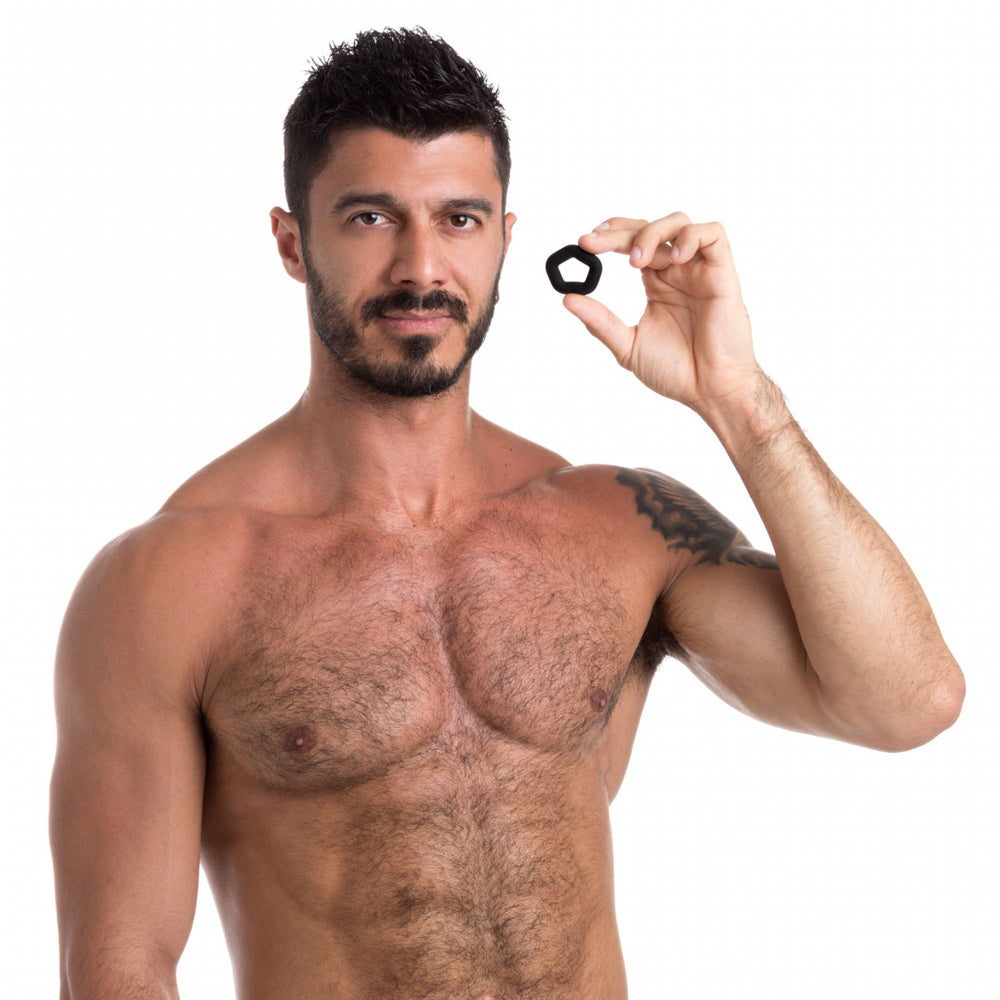 Man holding Sport Fucker Pentagon Silicone Cock Ring, showcasing its hexagonal design and skin-like feel.