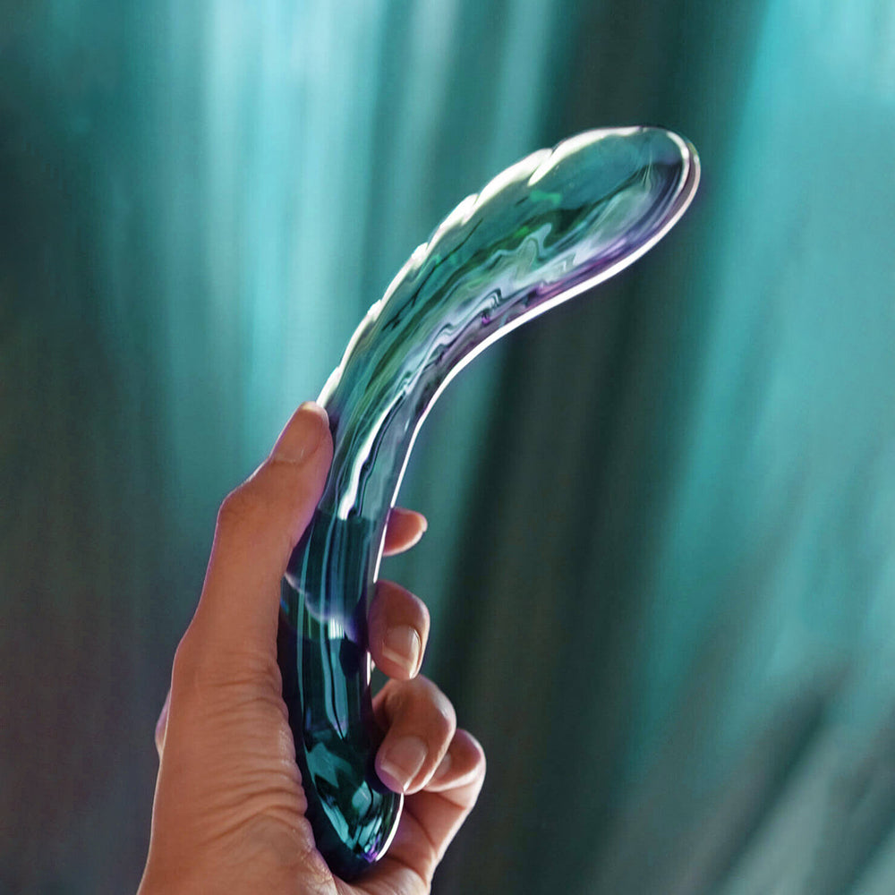 Biird Kalii Glass G-spot Dildo Teal held in hand showcasing its elegant design and smooth glass surface.