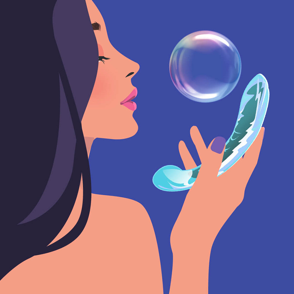 Biird Kalii Glass G-spot Dildo Teal held by a woman blowing a bubble, showcasing its elegant design and smooth surface.