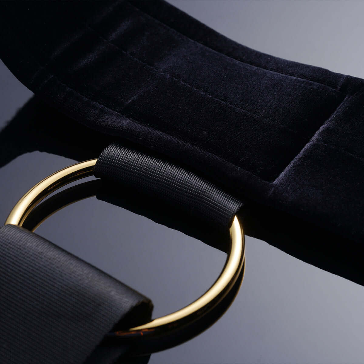 UPKO bondage gear sling featuring a soft black strap with a gold metal ring for adjustable use and comfort.