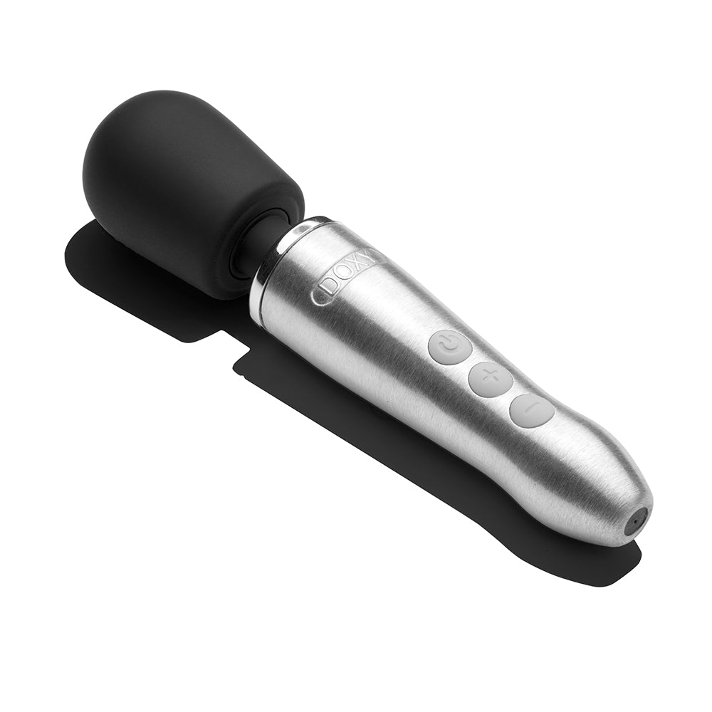Doxy Go Travel-sized Wand Massager Silver laid on a surface, showcasing its sleek design and powerful features.