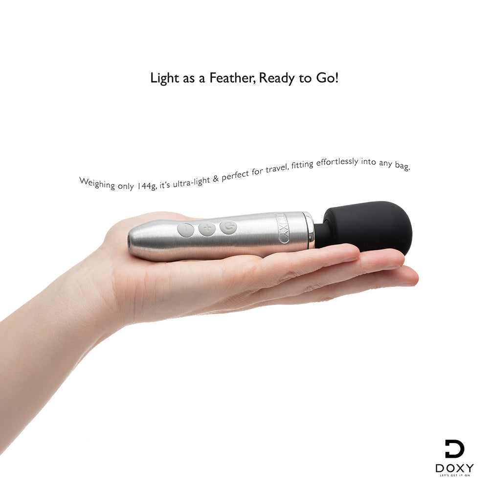 Doxy Go Travel-sized Wand Massager Silver held in hand, showcasing its compact and travel-friendly design.