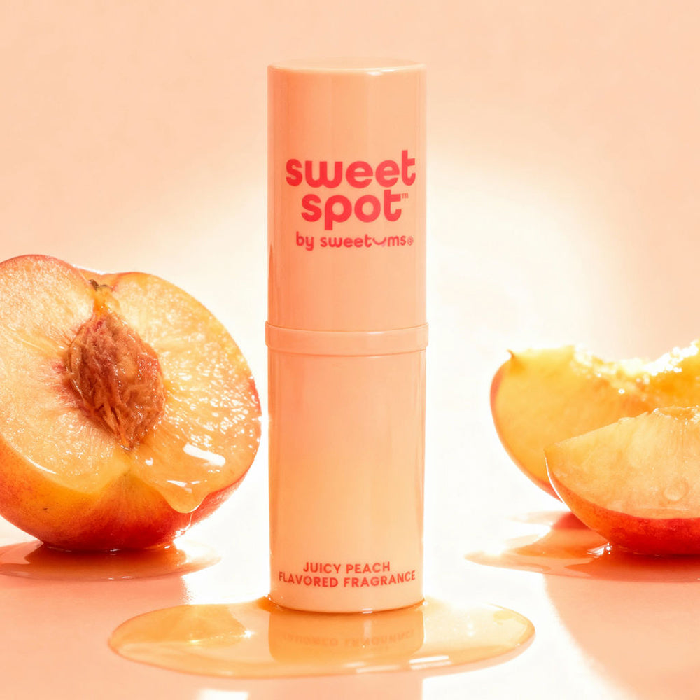 Sweetums Sweet Spot Flavored Fragrance Juicy Peach in a stick with fresh peaches.