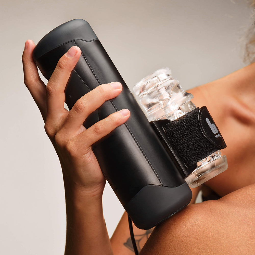 Person holding The Handy Interactive Stroker Black, showcasing its sleek design and interactive features.