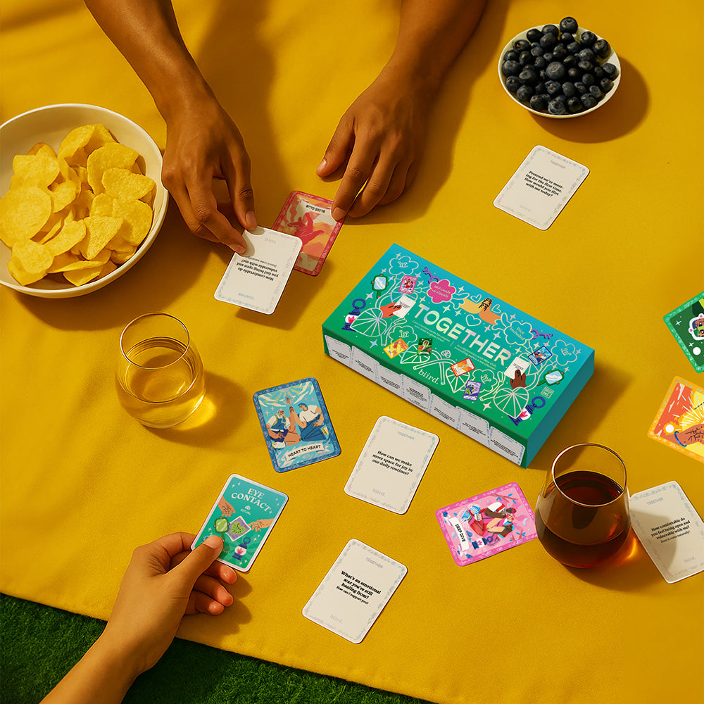 Biird X Jouissance Club Together Couples Card Game set up with cards, snacks, and drinks for meaningful conversations.