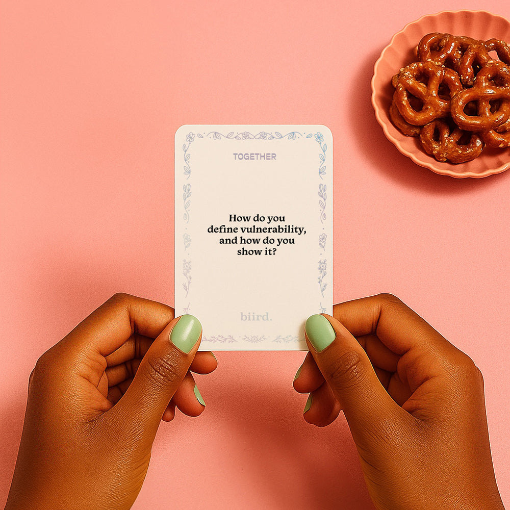 Biird X Jouissance Club Together Couples Card Game vulnerability question card held by hands with green nails.