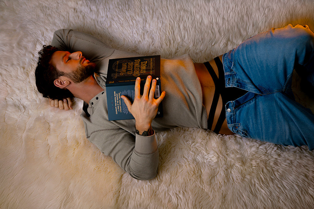 Male Power Eco Cozy Cutout Thong Green L XL model lying on a faux fur rug holding a book, showcasing comfort and style.