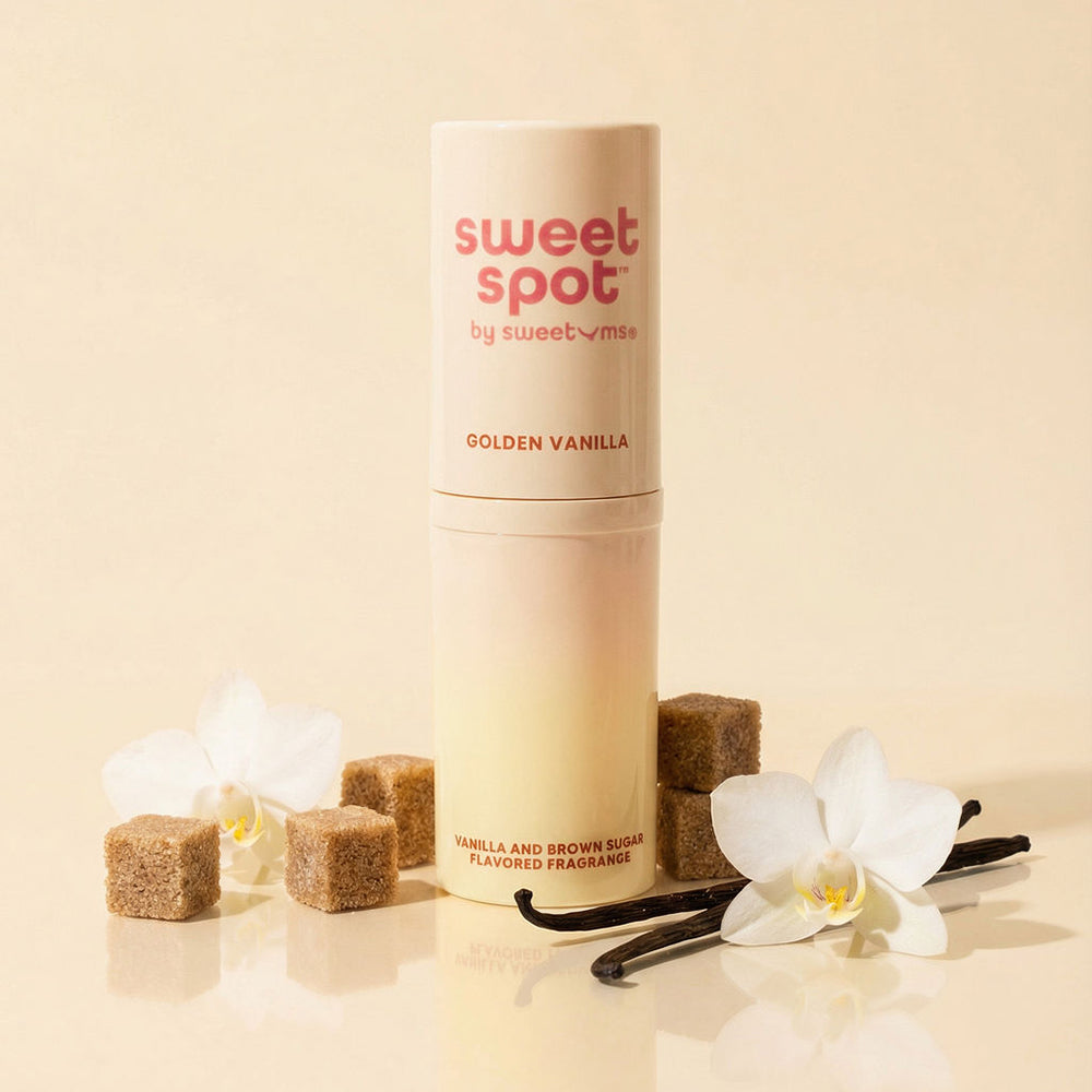 Sweetums Sweet Spot Flavored Fragrance Golden Vanilla stick surrounded by brown sugar cubes and flowers.
