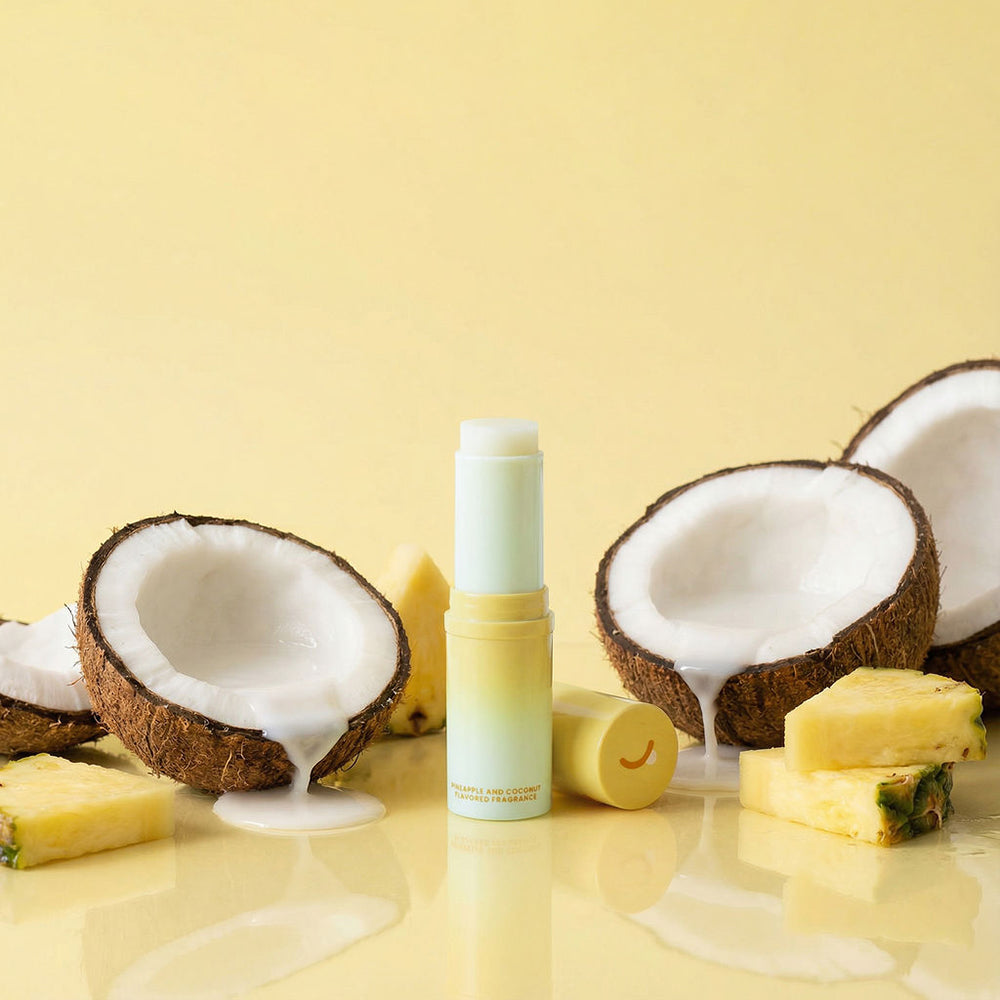Sweetums Sweet Spot Fragrance Pineapple Coconut Crush solid perfume next to coconut and pineapple.